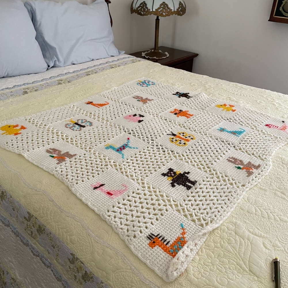 Handmade Crocheted Blanket with Cross Stitch Design, White Background.